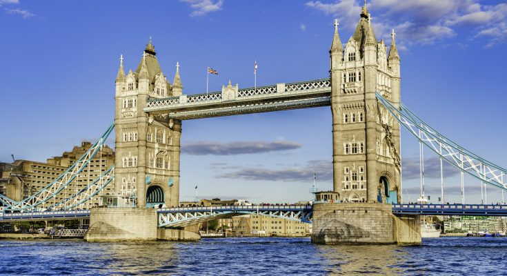 Historische Doppelturm-Klappbrücke vor blauem Himmel.