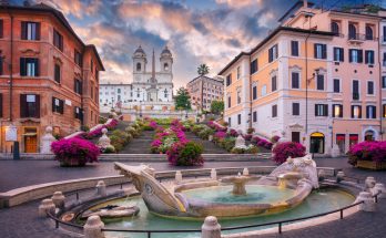 Fontana della Barcaccia vor blühender Spanischer Treppe und Trinità dei Monti.