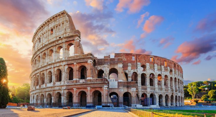 Das antike Kolosseum leuchtet im Abendlicht.