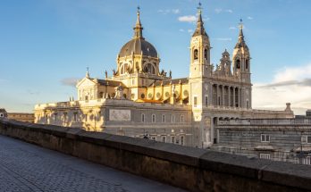 Blick auf Kuppel und Türme der Almudena-Kathedrale in Madrid bei Sonnenuntergang.