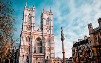 Gotische Abteikirche mit Doppeltürmen vor blauem Himmel.