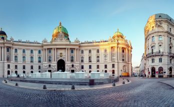 Barocke Hofburg-Fassade mit grünen Kuppeln am Michaelerplatz.