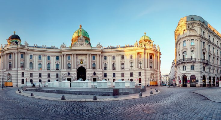 Barocke Hofburg-Fassade mit grünen Kuppeln am Michaelerplatz.