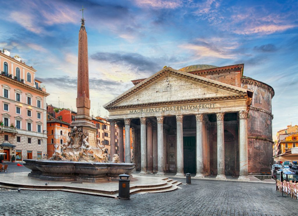 Pantheon mit korinthischer Säulenfront und Brunnen samt Obelisk bei Abendhimmel.